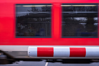 Bild: Bahnschranke und vorbeifahrender Zug