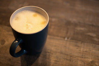 Bild: Milchkaffee in einer Tasse auf einem Holztisch