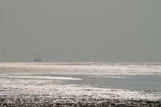 Bild: Wattenmeer (Nordsee) und Bohrinsel am Horizont