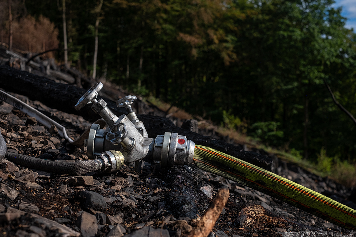 Bild: Feuerwehr. Verteiler für Wasserschläuche (hier bei einem Waldbrand)