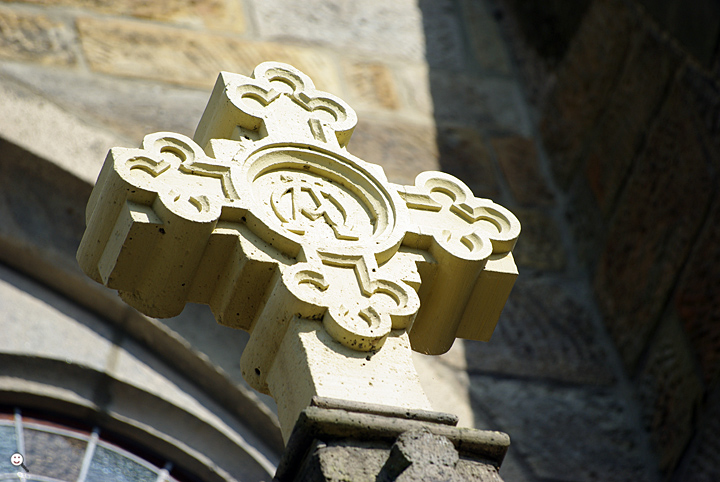 Bild: Kreuz mit den Zeichen Alpha und Omega (erster und der letzter Buchstabe des klassischen griechischen Alphabets)